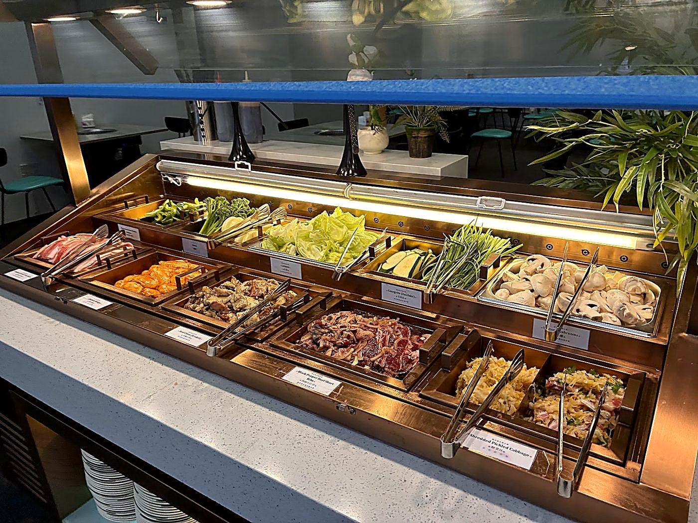 Raw BBQ meats and fresh vegetables counter